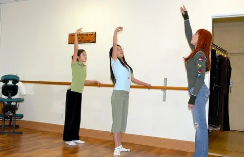 Nicole Brandon teaching young girls ballet at a dance studio bar